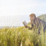 A man reading a book in nature